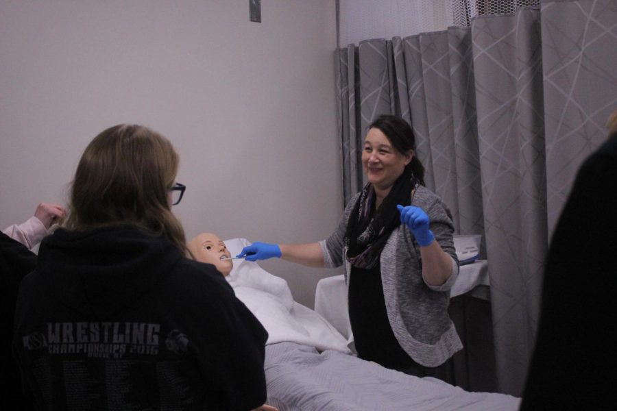 CNA instructor Mrs. Wasalaski demonstrates how to brush a patients teeth while they are on the operating bed. On of the biggest skills the kids learn in here is empathy, Mrs. Wasalaski said. Empathy makes the job easier and will carry over to the rest of life. Each student must demonstrate his/her skills back to Mrs. Wasalaski over the course of the semester. Photo by Ethan Menning