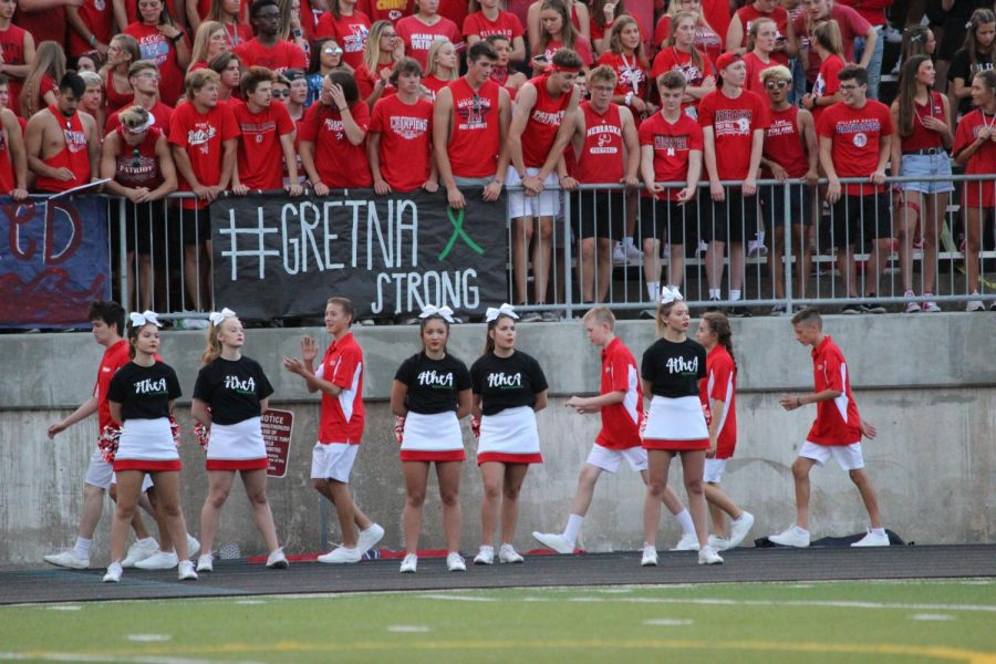 Millard South showing good sportsmanship with the cheerleaders wearing 4the4 shirts and their student section having a Gretna Strong banner.