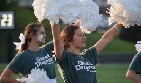 The cheer finishes and Junior Lily Brown raises her arms as she spirits to the crowd.