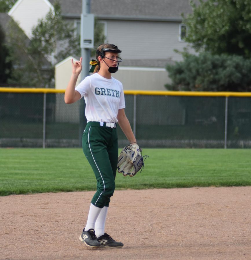 The shortstop, freshman Shaylynn Campbell, showing the team that there are two outs. 