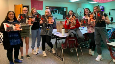 The Vanguard staff holding prints of the magazines they created. Junior Peyton Rewczuk printed them out as a Christmas present to her favorite class.