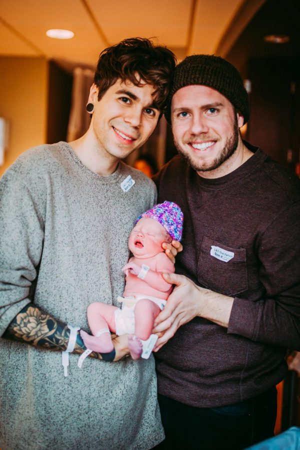 Elliot and Matthew holding their new  baby, Uma.