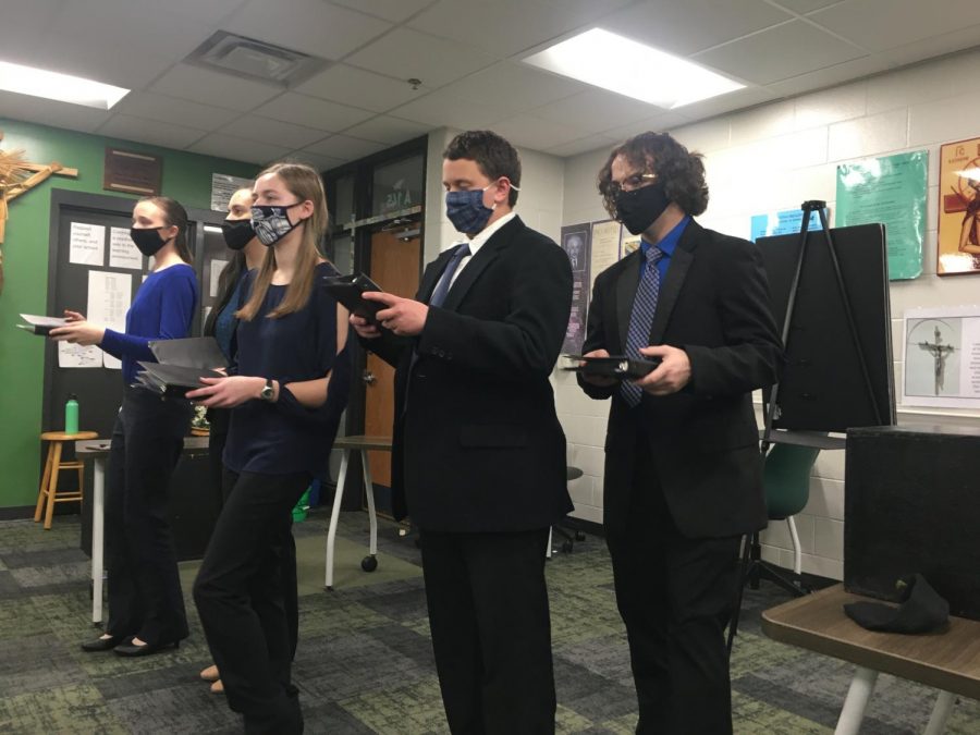 Book Smarts Lining up the Oral Interpretation of Drama (OID) rehearses their introduction. OID consists of four to five students. Their script was Coraline.