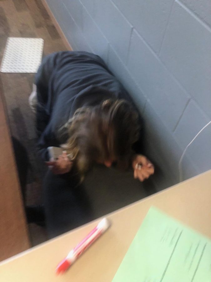 Stop Drop and Crawl. During AEP Jenna Wardyn (25) hides under desks and chairs so that she can’t be tagged. Taggers take photos through doors and windows to avoid disrupting classes.