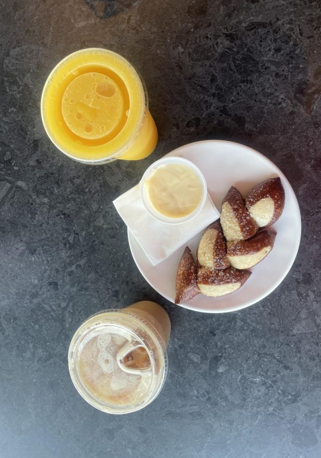 DELICIOUS. On the left sits a tangy mango smoothie, then a serving of pretzel bites that were divine and the sweet Beez Kneez Latte. 