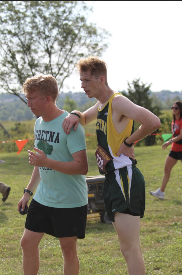 PUSHING THROUGH - Exhausted after a race earlier in the season, sophomore Brady Donahue leans on his Coach Ian Meador who held him up.