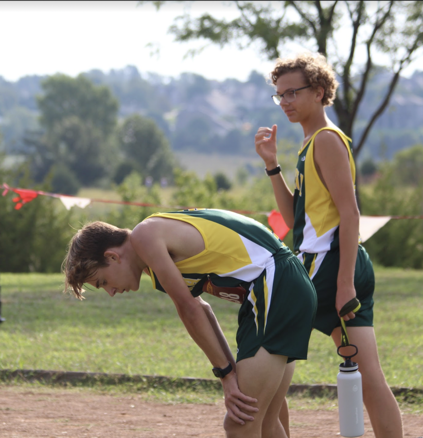 STRUGGLING - Senior Cole Johns bent over breathing hard after the long race earlier this season. He pushed through and made it to the finish line.