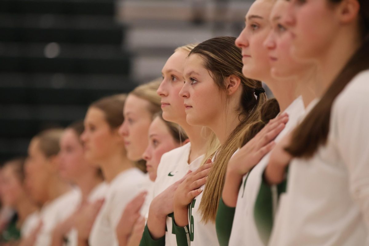Sophomore Bella Rangel stands in the center for the pledge of allegiance with her teammates, sophomore Halle Mason on her left and senior Cassie Stones on her right.
