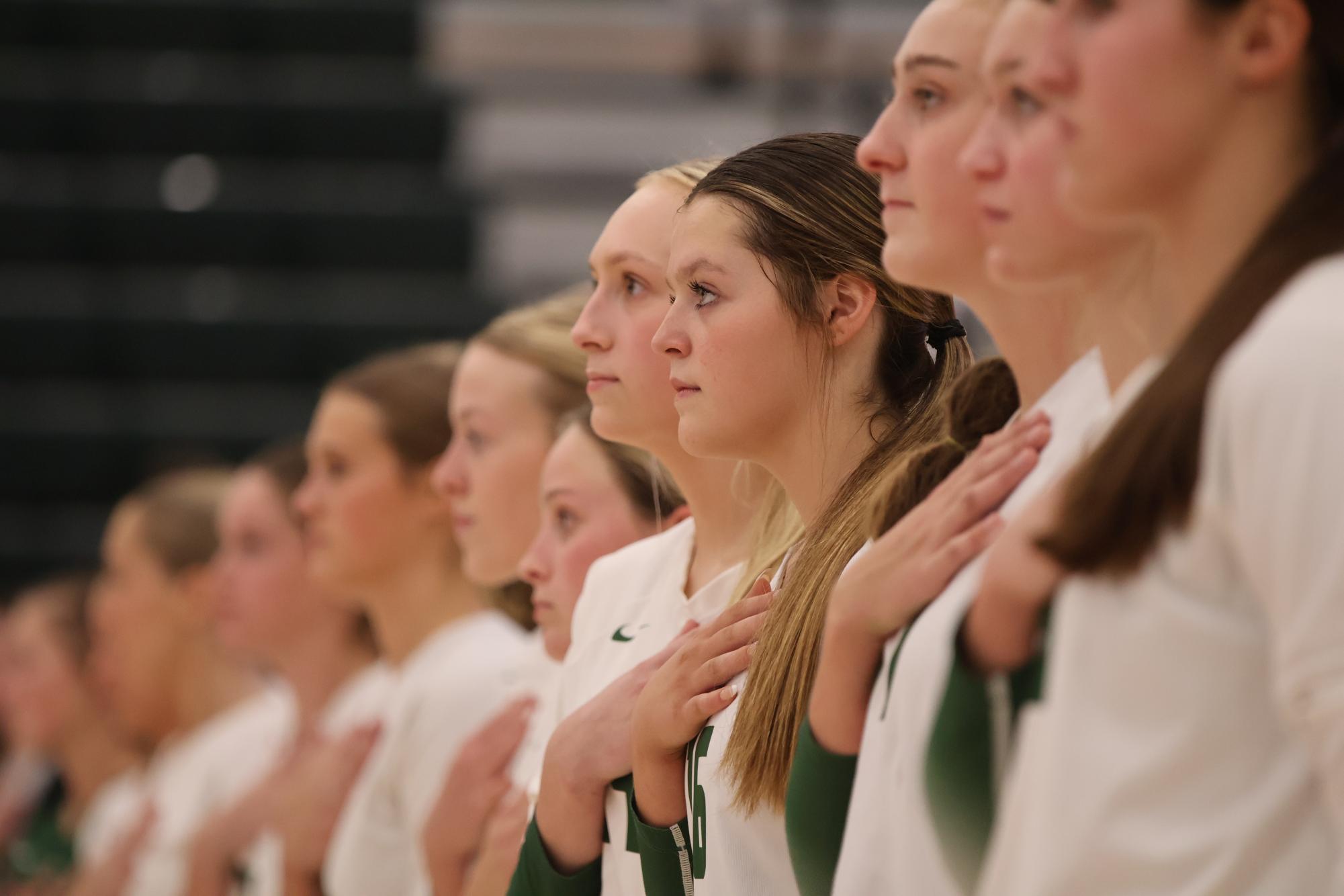 Sophomore Bella Rangel stands in the center for the pledge of allegiance with her teammates, sophomore Halle Mason on her left and senior Cassie Stones on her right.
