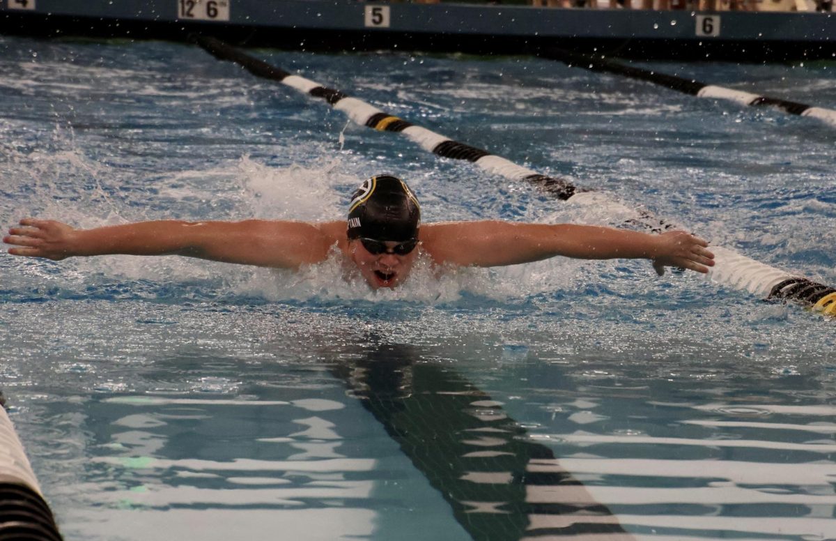 Junior Alex Hallgren works to beat his time at the first ever YMCA swim meet vs Millard West.
