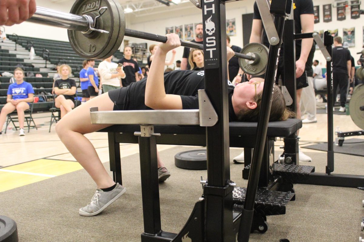 Sophomore Caitlyn Cheleen lieft up the bar during the bench press. 