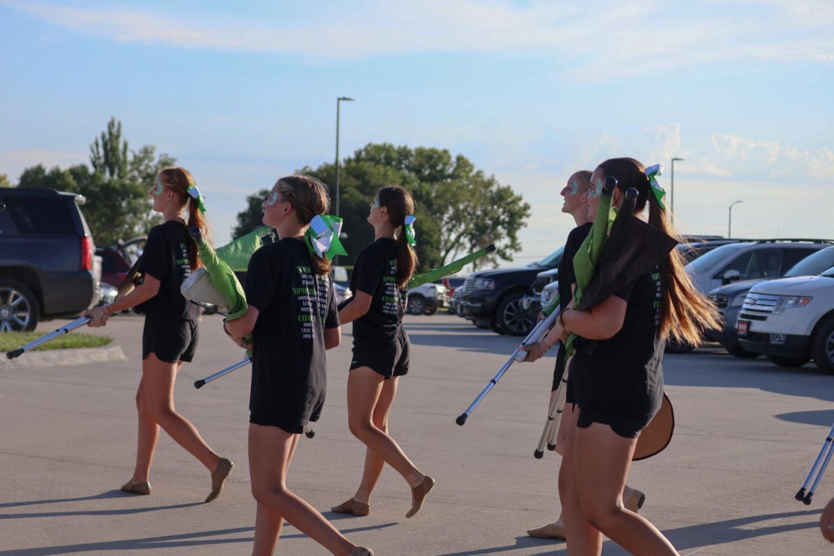 Amelia Onwiler (26), Kyler Wolff (26), Rebecca Roberts (26), Mallory Suggitt (26) and Kelsey Noonan (26) head toward the GHS football field ahead of the GHS Marching Band. They performed their show for this year, "Gusto Italiano: A Taste of Italy," at their expo on August 6.