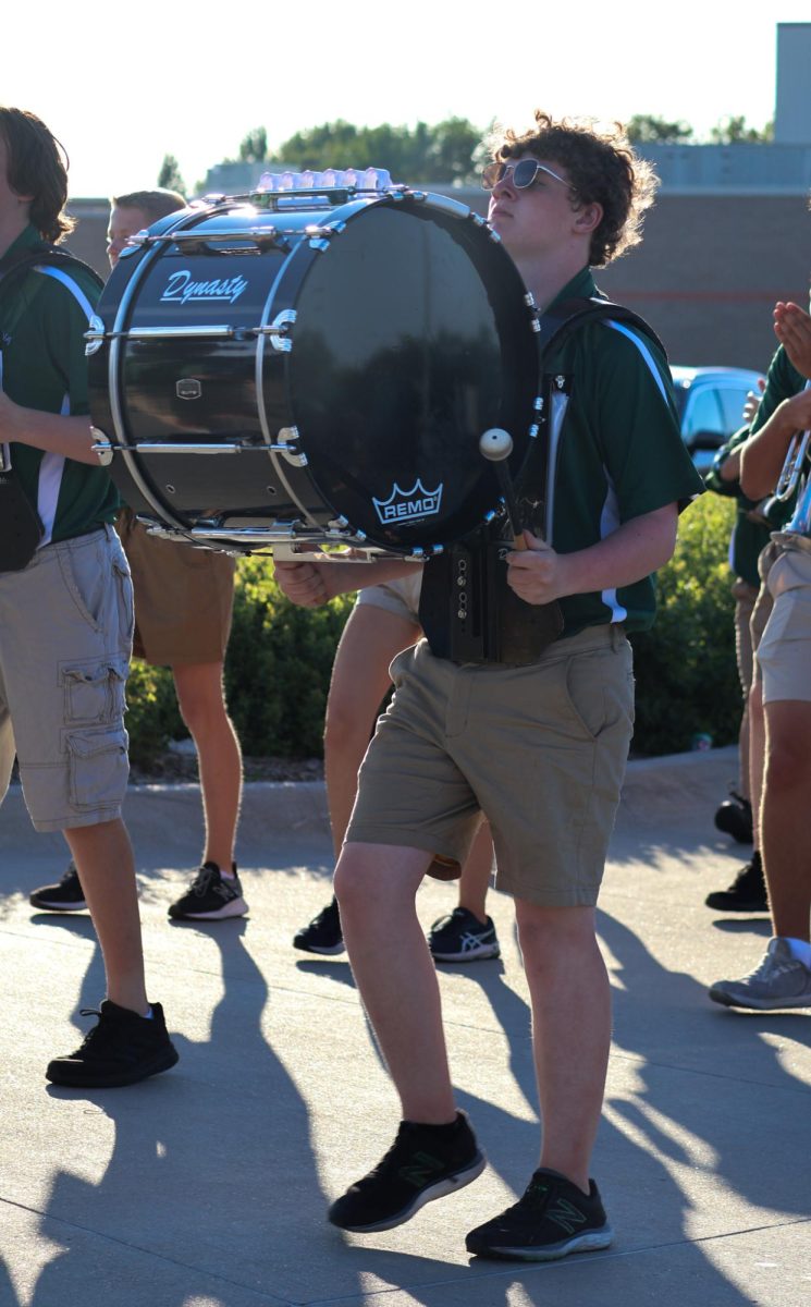 John Carson (26) beats a drum alongside other percussion members of the GHS marching band on his way to the football field. They performed their show for this year, "Gusto Italiano: A Taste of Italy," at their expo on August 6.