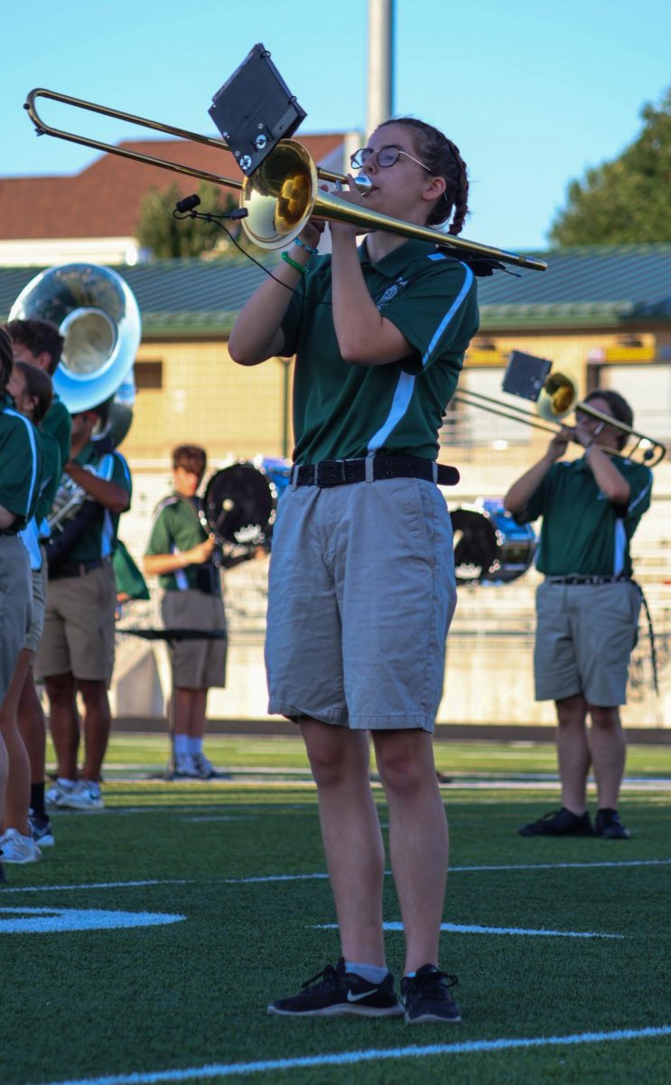 Charlotte Cullison (27) marches in place as she plays the trombone on the GHS football field. They performed their show for this year, "Gusto Italiano: A Taste of Italy," at their expo on August 6.