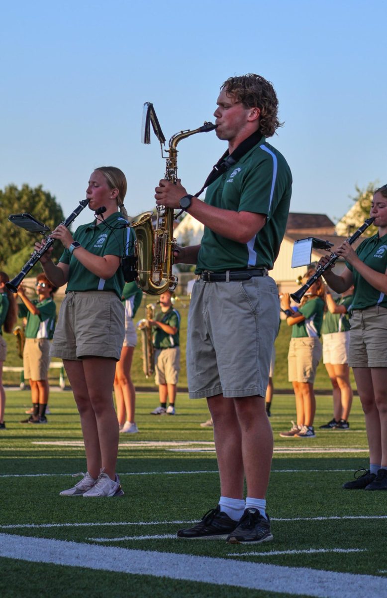 Alex Hallgren (25) plays the saxophone alongside other marching band members on the GHS football field. They performed their show for this year, "Gusto Italiano: A Taste of Italy," at their expo on August 6. 