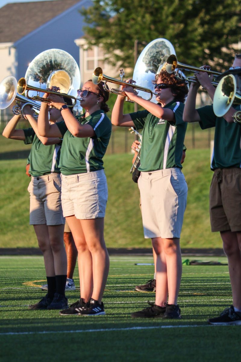 Adeline Longbotham (27) and Lucy Sanfilippo (27) play the trumpet in line with other members of the GHS Marching band on the football field. They performed their show for this year, "Gusto Italiano: A Taste of Italy," at their expo on August 6.