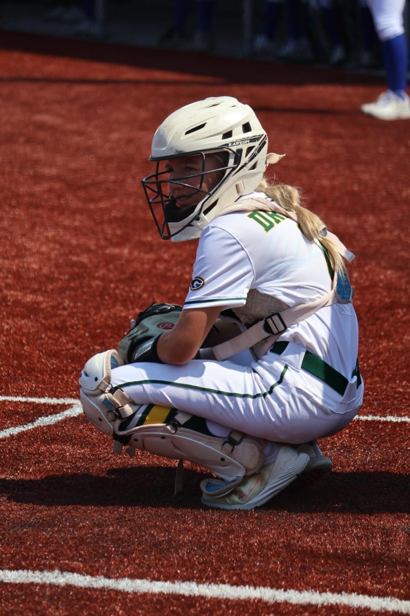 Catcher Emerson Boyer (26) looks toward her coach to get the next pitching sign at the Gretna vs. Omaha Marian scrimmage on Aug. 17. Coach Nixon said, "We don't focus on winning, so we focus on being great teammates and competing all the time."