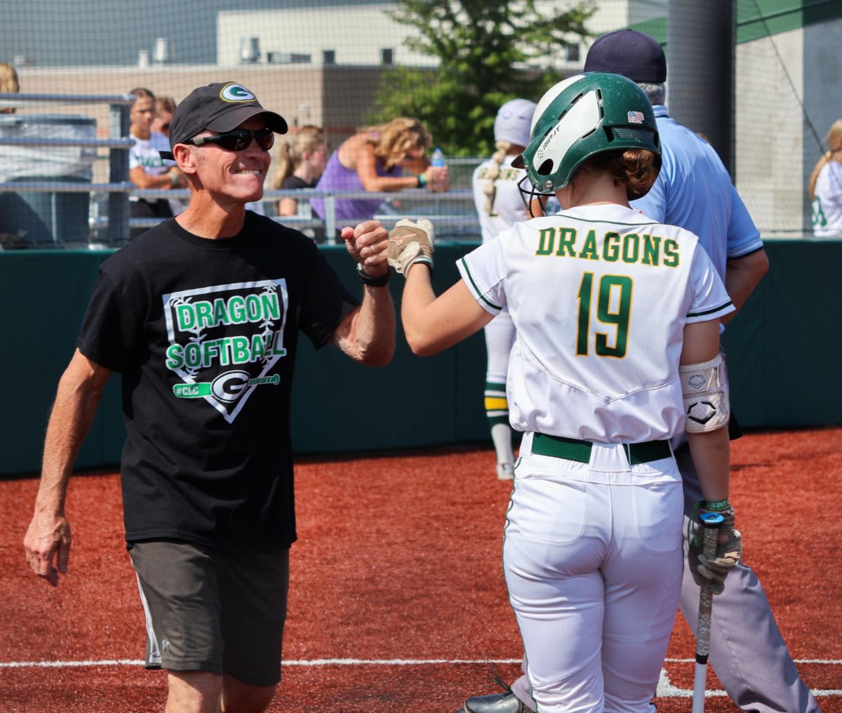 Coach Todd Mills and center fielder Anniston Trevarrow (25) fist bump during the Gretna vs. Omaha Marian scrimmage on Aug. 17. “We want everybody to have a great experience playing softball for Gretna," Coach Heard said. "We want as many people as we can have because the more people we have, the bigger our family is.” 