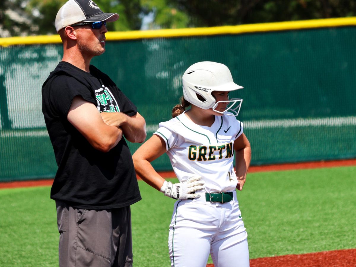 Coach Bill Heard and daughter Brylee Heard (26) study the pitcher during a pitcher change at the Gretna vs. Omaha Marian scrimmage on Aug. 17. “All of it is hard,” Coach Bill Heard said. “Everybody has to be willing to sacrifice for the betterment of the team.”