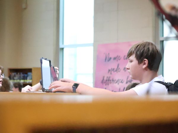 Max Simonsen (28) works on his new, school-issued laptop with other freshmen after receiving it from the tech staff during fifth hour at Freshmen Day on Tuesday, Aug. 13.