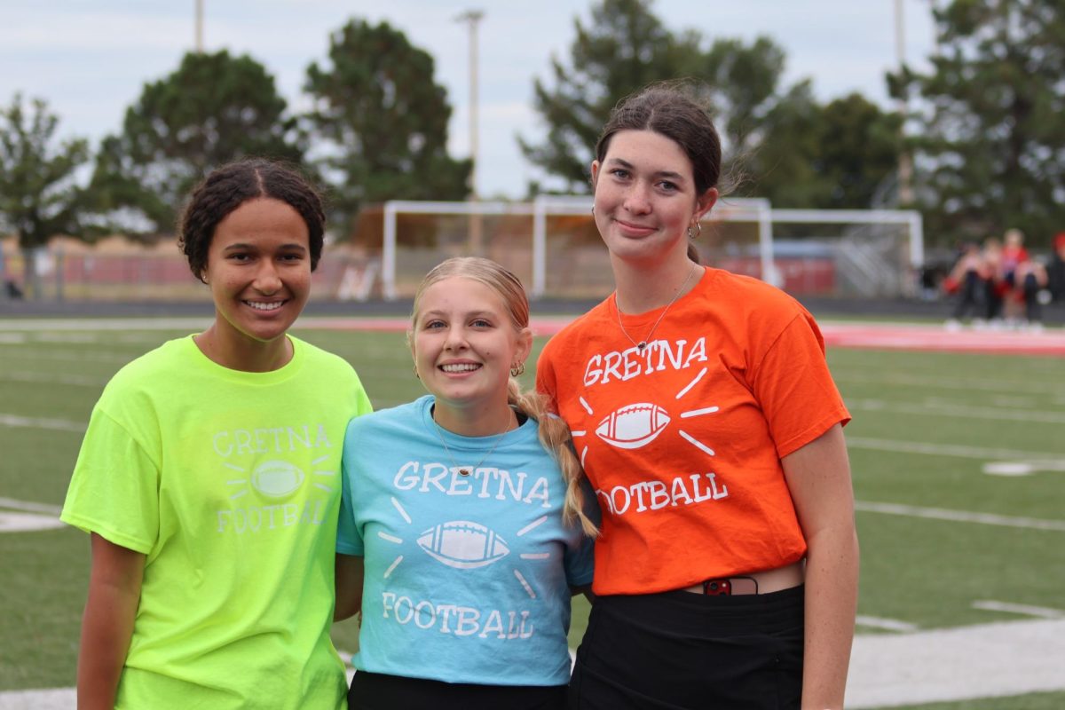 Football managers sophomore Avery Holston and juniors Sarah Kula and Sarah Doble pose prior to the game against Norris. “The coaches have to coach, the players have to play and the athletic trainers have to focus on injury and recovery," Kula said. 