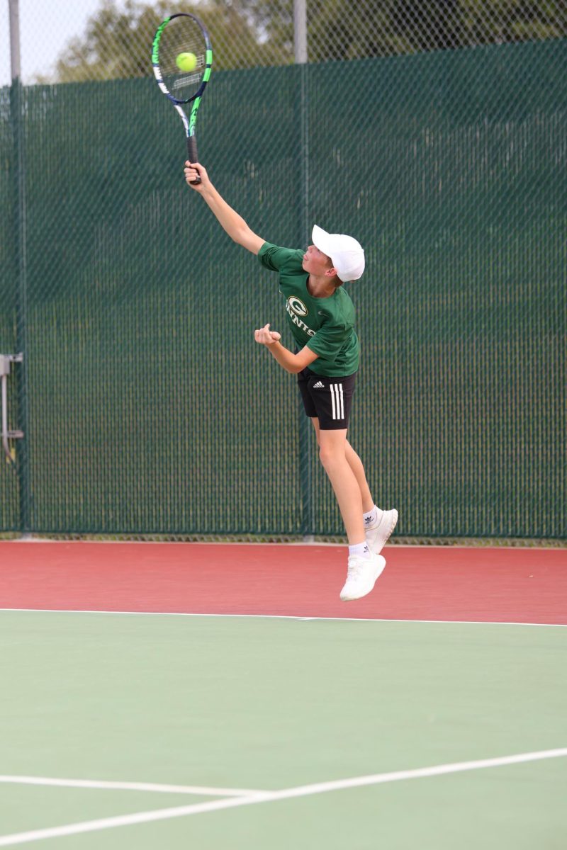 Freshman Brayden Stamm makes contact with the ball during his first serve.