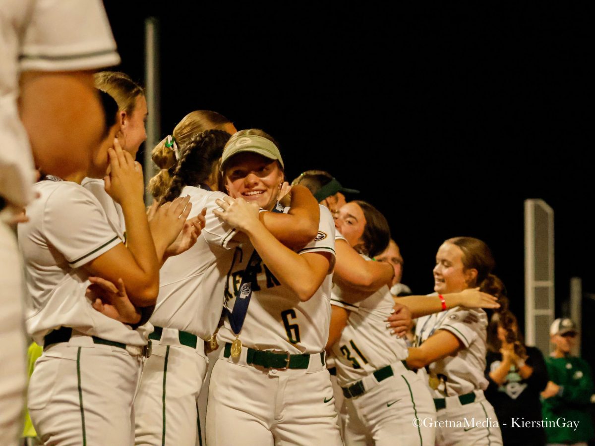 The team shares the love of the win with senior Lily Rowe as she receives a hug. 