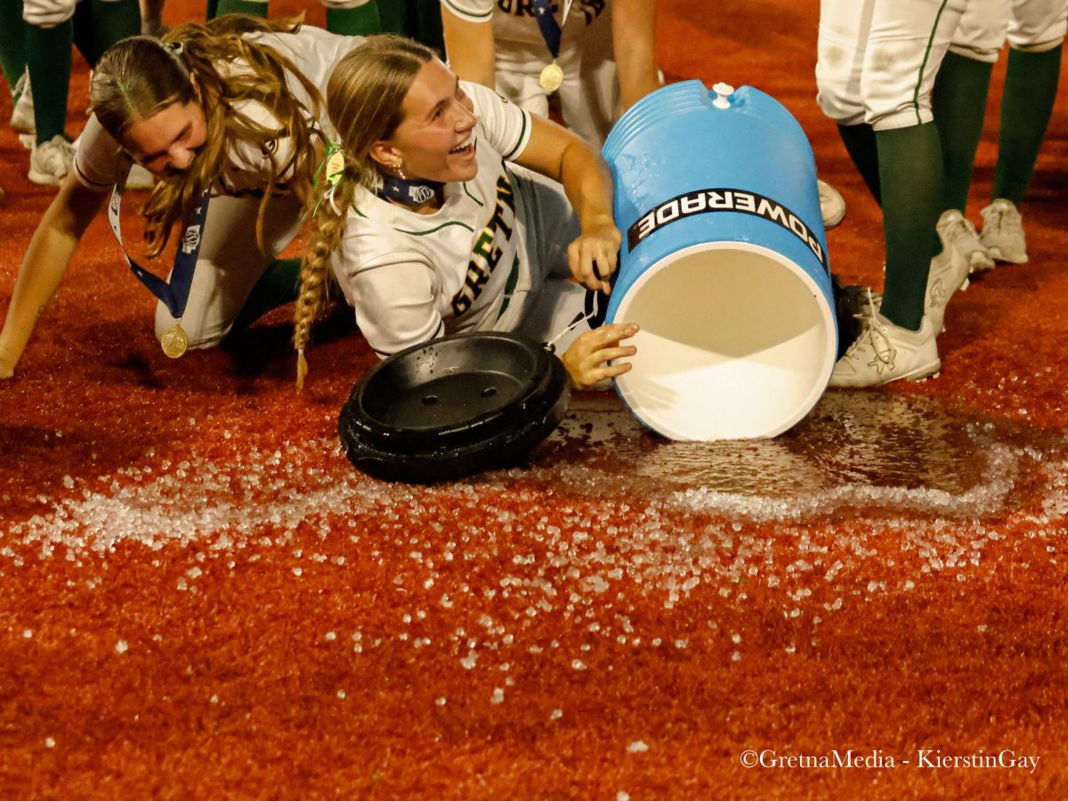 The softball team attempts to dump a jug of water on Head Coach Bill Heard to celebrate their victory, but the Rupiper sisters and the water end up on the ground.