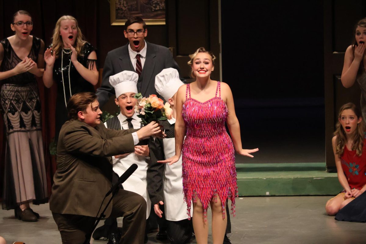 Senior Drew Miller presents senior Claire Miller with a bouquet.