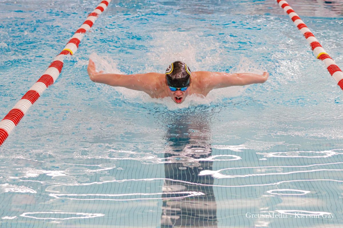 Senior Alex Hallgren makes his way toward the wall, cutting it close during his race on Saturday, January 11 at Millard South High School.