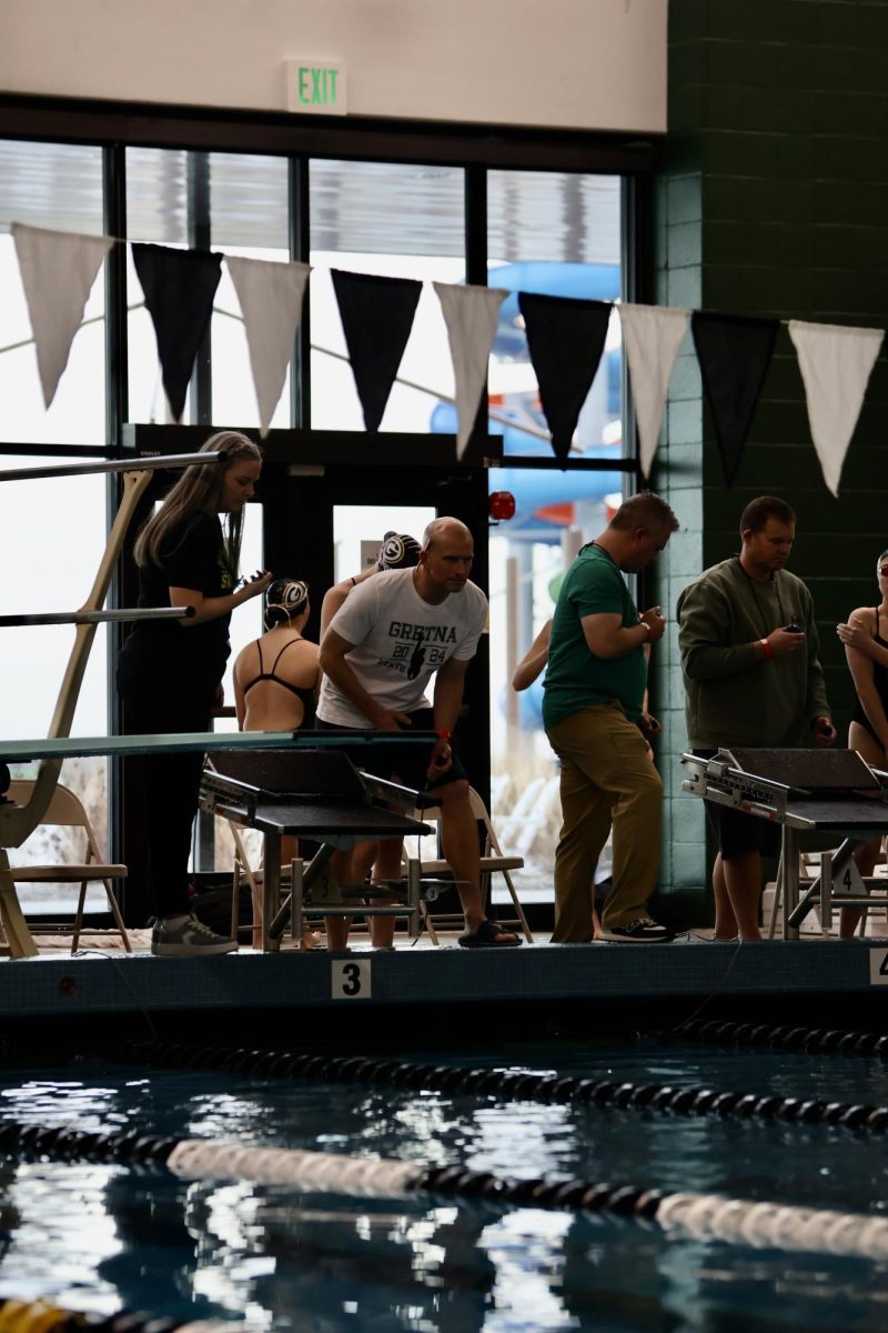 Timer Clint Siskow watches a swimmer during their race to get an accurate time. 