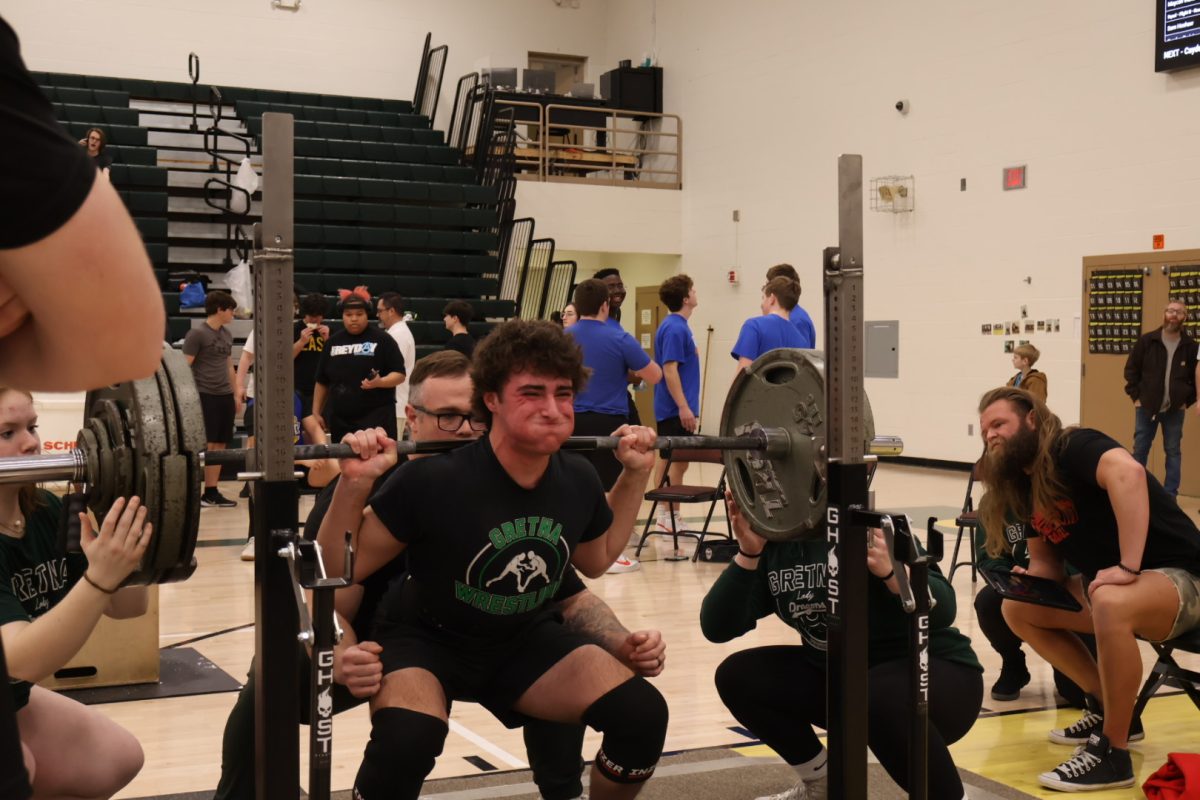 Sophomore Andrew Gumm holds his breath during his attempt of 350 pounds for his final squat attempt during the GHS powerlifting meet. Gumm placed sixth in his weight class.