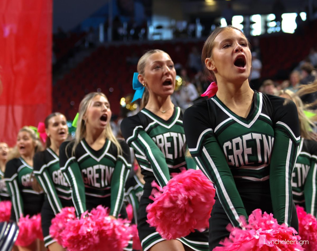 From right, cheerleaders sophomore Emmy Miller, junior Savannah Dirks and senior Ellie Melton in the middle of a cheer at the NSAA State volleyball tournament.
