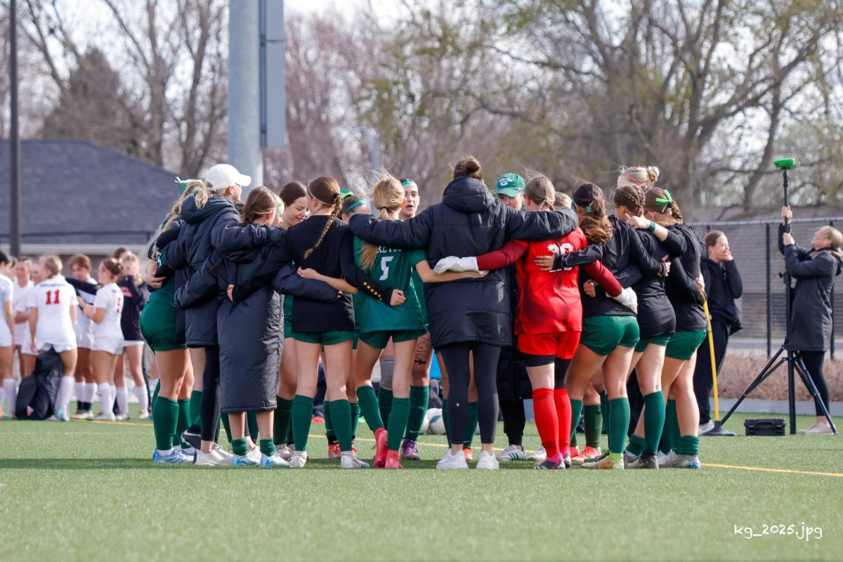 The soccer team gathers together at a game. The team's chant is "we can and we over me."