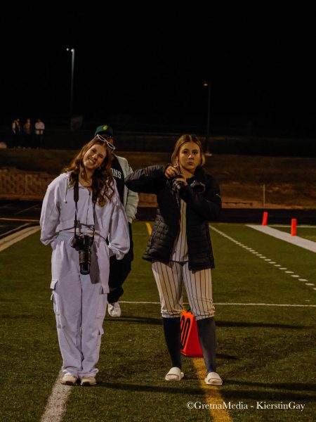 Freshmen Claire Palser and Callie McGee pose together while taking pictures at a Gretna football game at the GHS field.