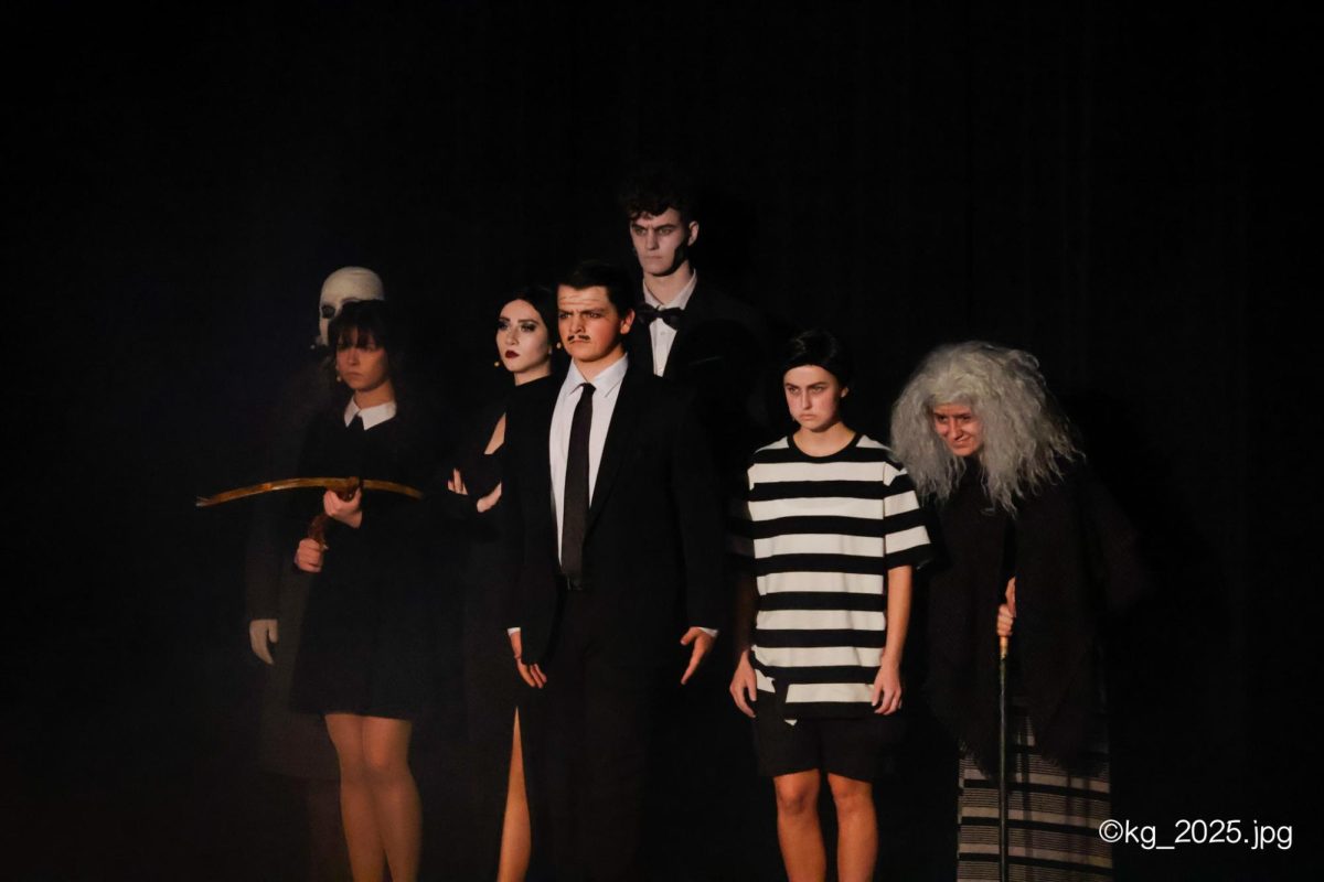 Senior Drew Miller, junior Mary Jane Kushiner, seniors Hannah Boldt, Clayton Angland, Josiah Hayden and junior Haley Burtwistle are arranged in the classic "Addams Family" position as they are introduced to the audience to begin Act 1 of "The Addams Family".