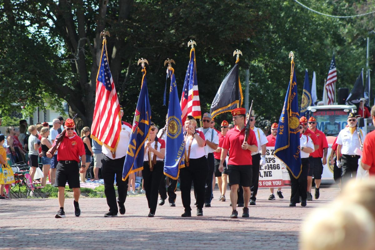 Members of the Gretna American Legion Post 216 carry US and Nebraska State flags and rifles to represent their post during the Gretna Days Grand Parade.