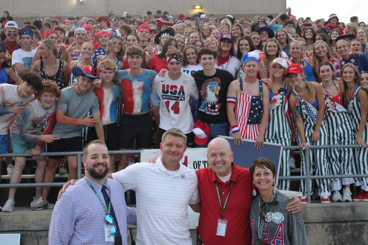 Gretna's principal and vice principal -- Zach Fleer, John Heckenlively, Trenton Steele and Theresa Huttmann -- pose in front of the Green Army student section at the homecoming game. The Dragons beat Blair on Sept. 11.  