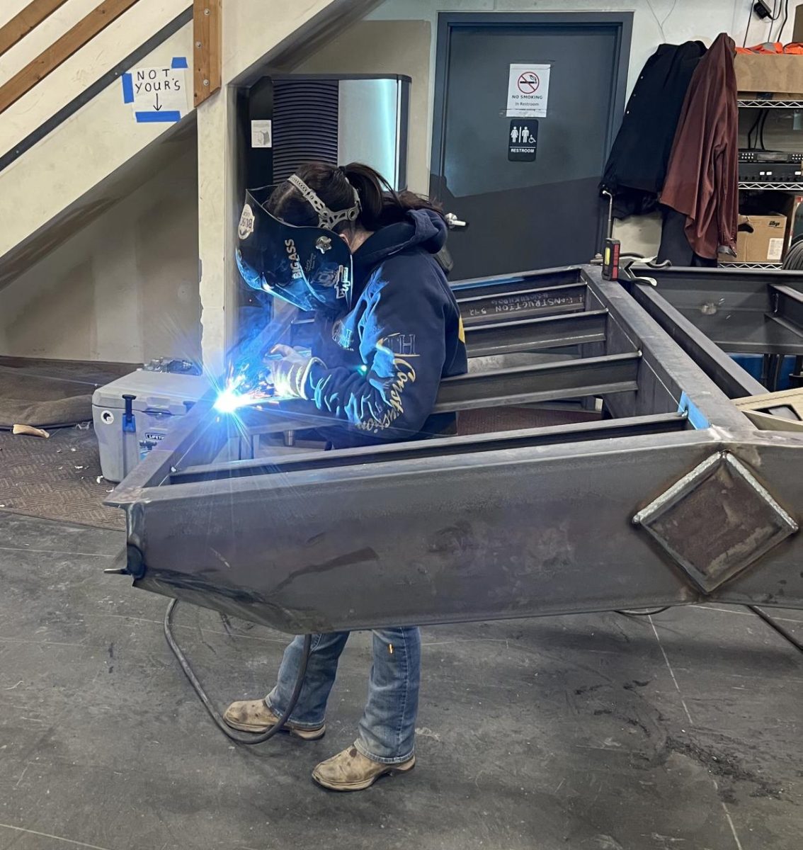 Welding teacher Cadance Rohrer works on a project. Rohrer used to work as a trailer fabricator, and uses that experience to guide and relate to her welding classes. "I'm just excited to be a teacher, because welding is fun and you can learn the skill, learn the trade, and go straight into the workforce." Photo courtesy of Cadance Rohrer.