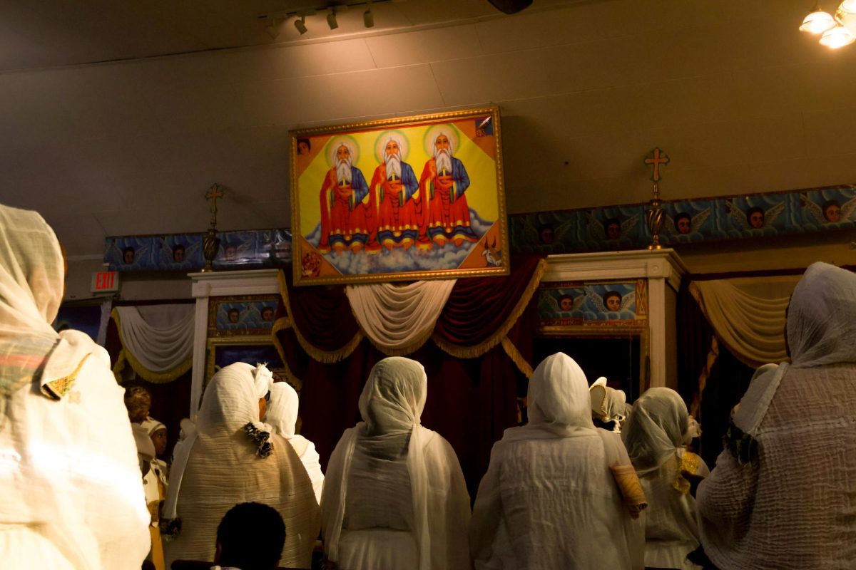 Members of the Ethiopian Orthodox Tewahedo Church choir sing together at the front of the chapel with the Holy Trinity displayed above them. "I want my kids to value love, love for others, love for God and love for themselves. God had 99 angels but he sacrificed himself for the salvation of Adam," Aster Haile said.