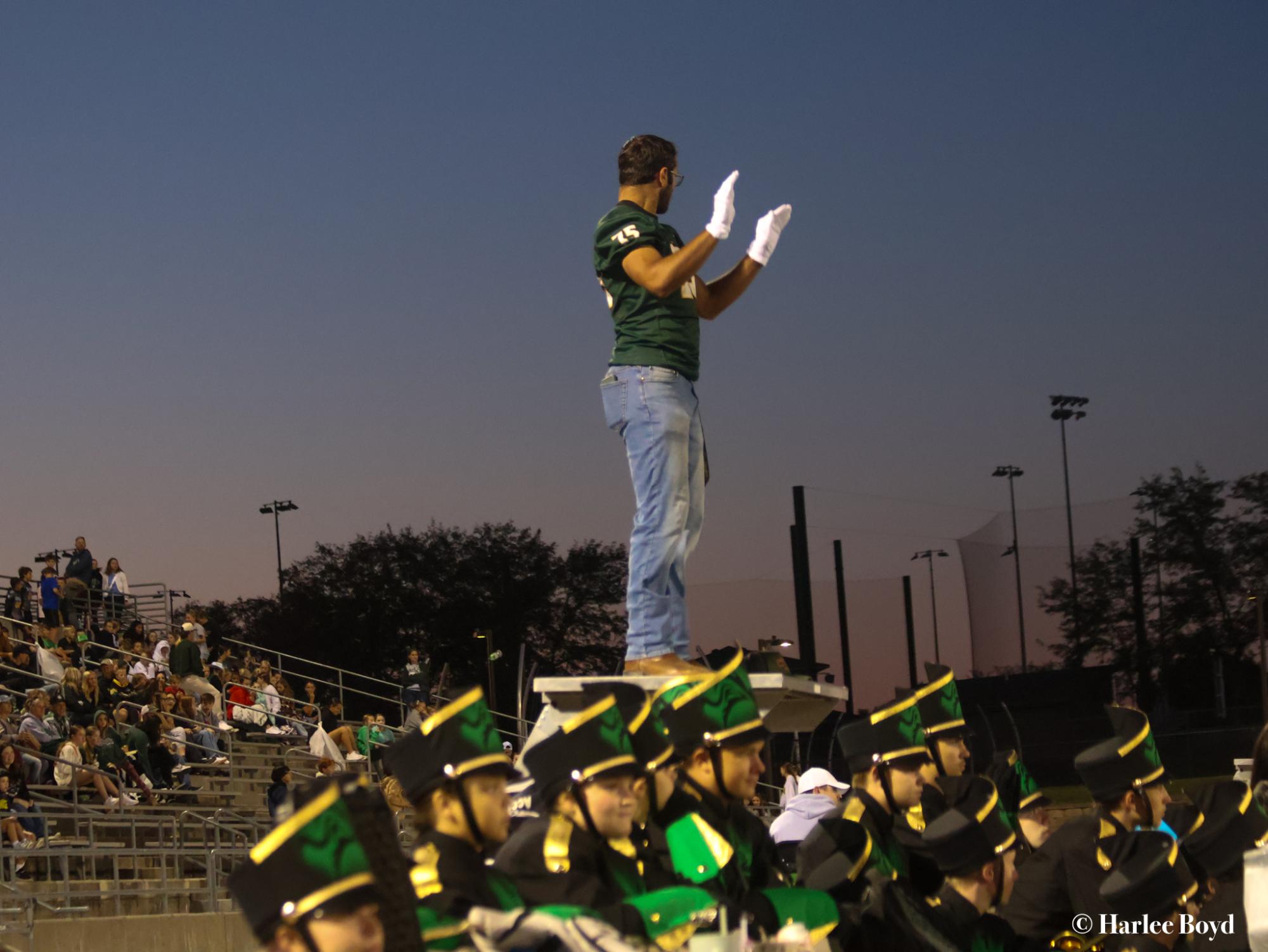 Senior Grant Barnes directs the marching band during a football game in September. Being a drum major is just one of the many activities Barnes takes part in. 