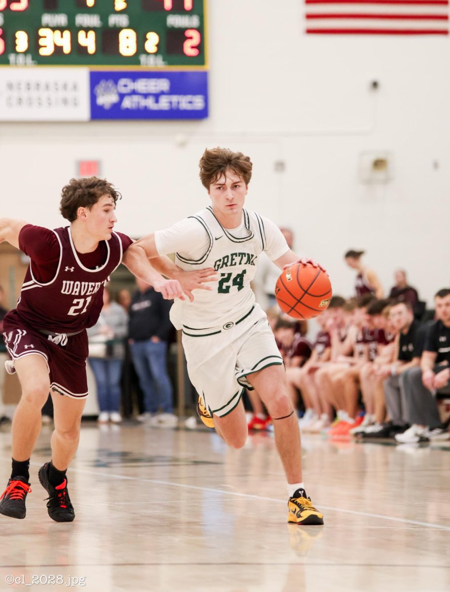 Senior Treven Wilkens drives the ball down the court during Gretna's game against Waverly. "The way me and my teamates were able to move the ball around well and that created open shots for me," Wilkens said on how he was able to score 21 ponts in the win over Waverly on Jan 8.