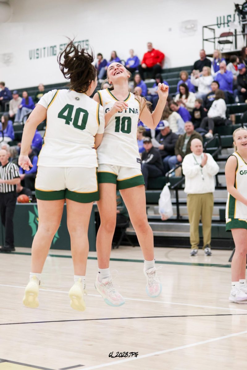 Juniors Ava Mcrator and Anna Weberg jump into the air during their pregame intorduction celebration.