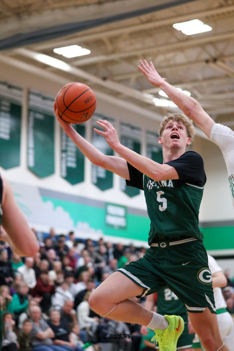 Junior Lucas Hack drives to the basket, jumps right and puts up a hook shot over a Skutt defender. 