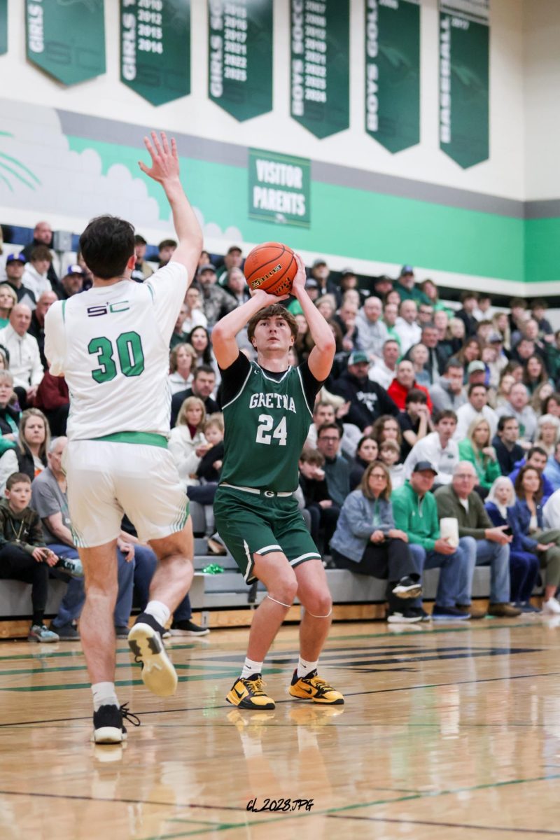 Senior Treven Wilkens shoots the kick out three pointer to put the Dragons over Skutt Catholic early in the first quarter.