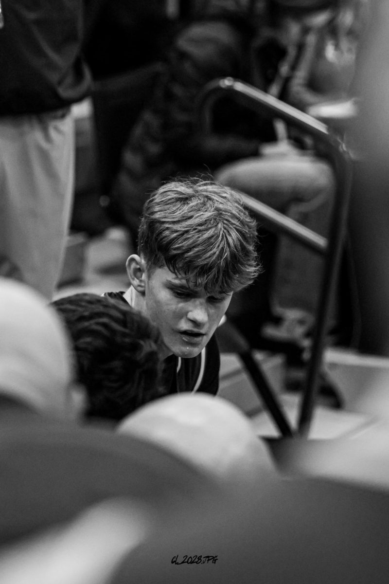 Senior Brandtley Hack sits in the huddle while the Dragons discuss their game plan.