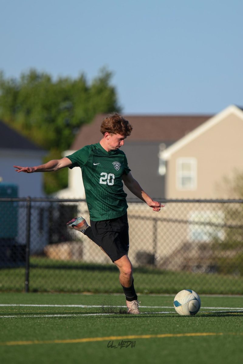 Senior Brady Cerone dribbles toward the corner kicks the ball across the field to setup a scoring chance.